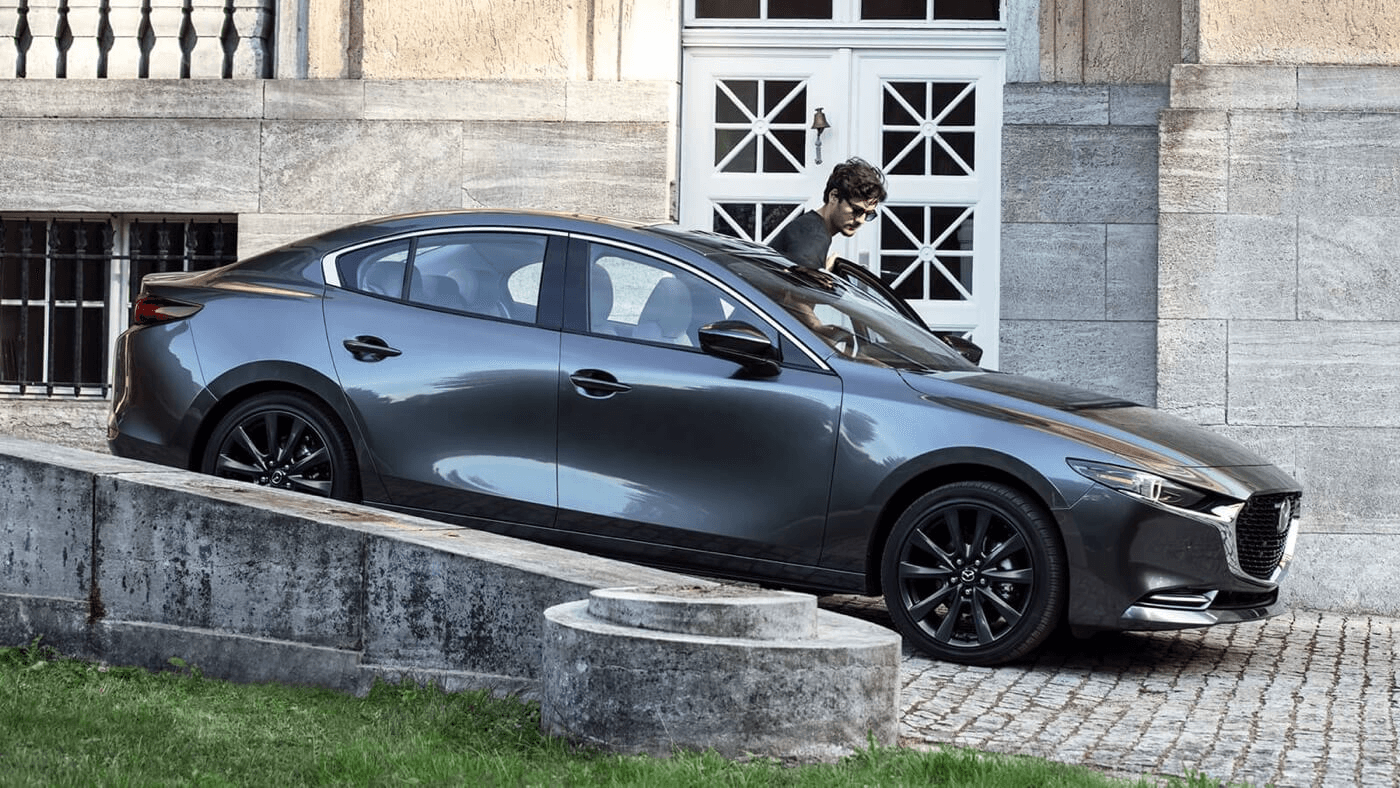 Le Mazda3 2025 garé sur un pavé.